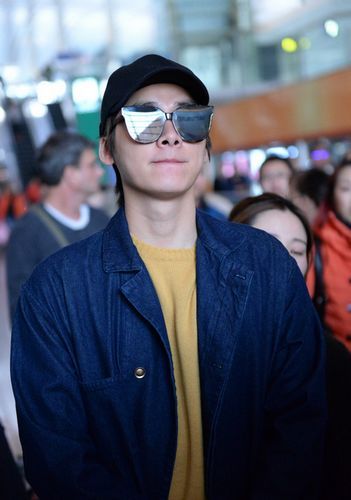 2月12日，李易峰身着黄T、长风衣现身机场，黑超遮面酷拽十足，获众多粉丝接机人气爆棚。